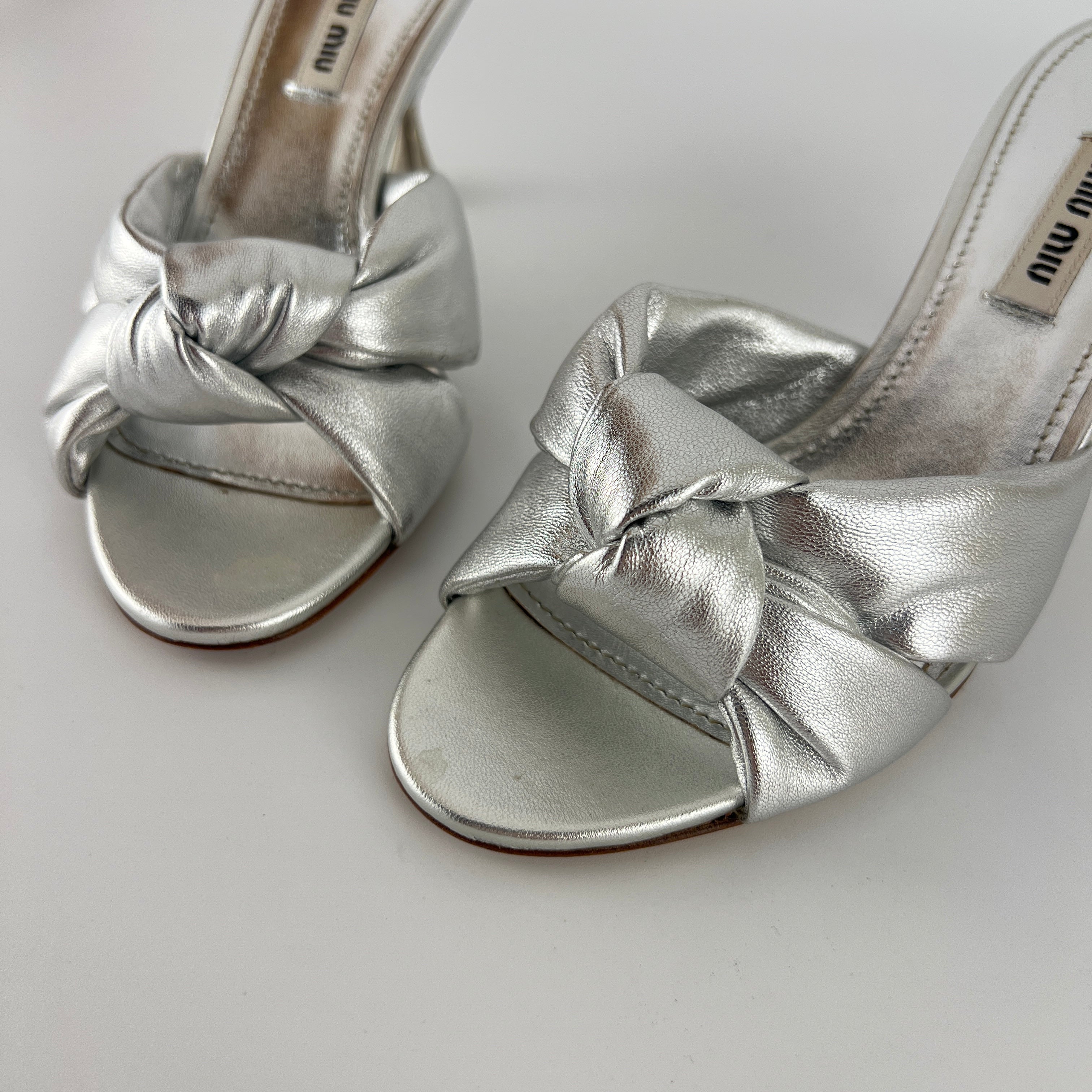 Miu Miu | Metallic Silver Leather Knot Metal Heel Slide Mules (37)
