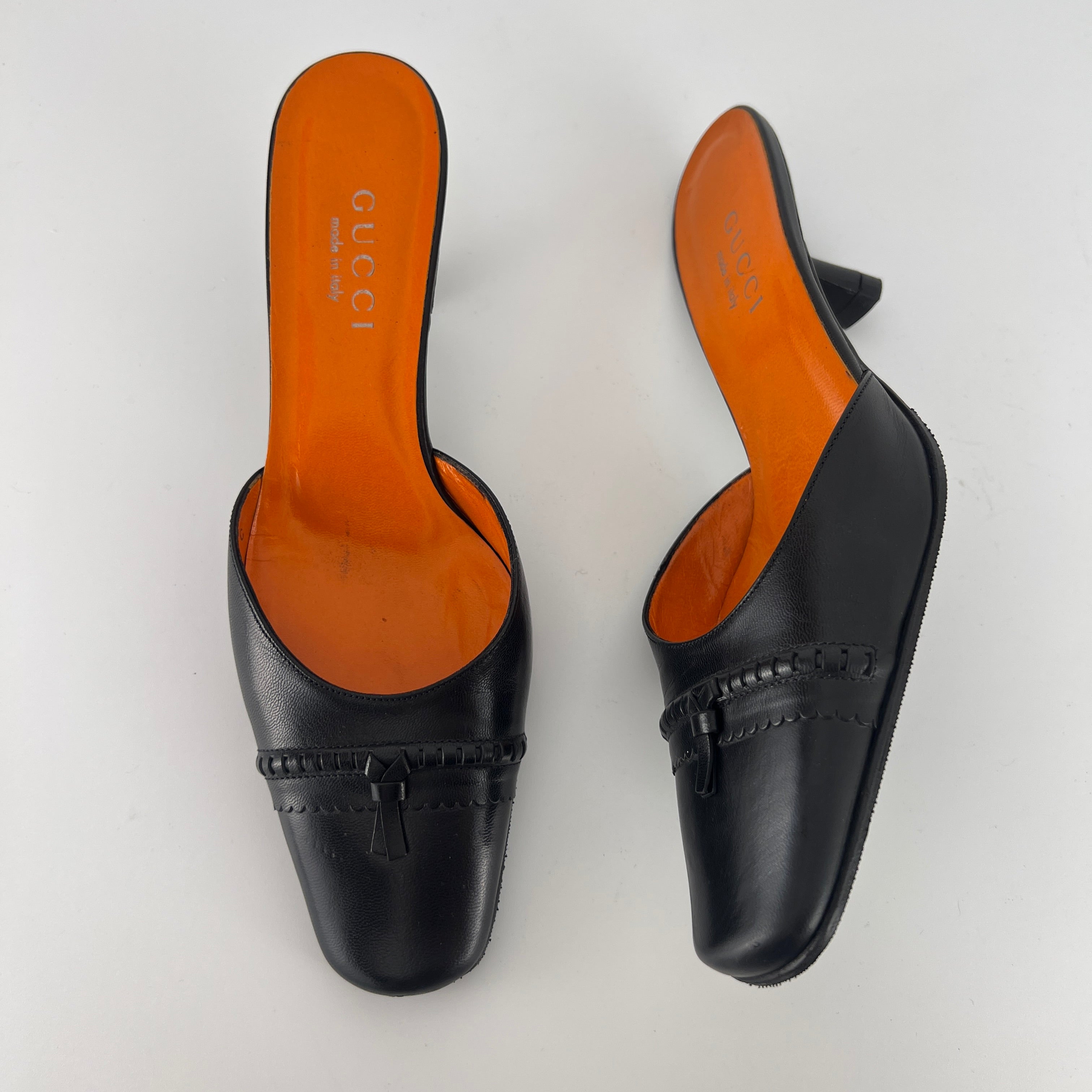 Gucci | Black Leather Closed Toe Brogue Tassel Orange Insole Mules (37C)