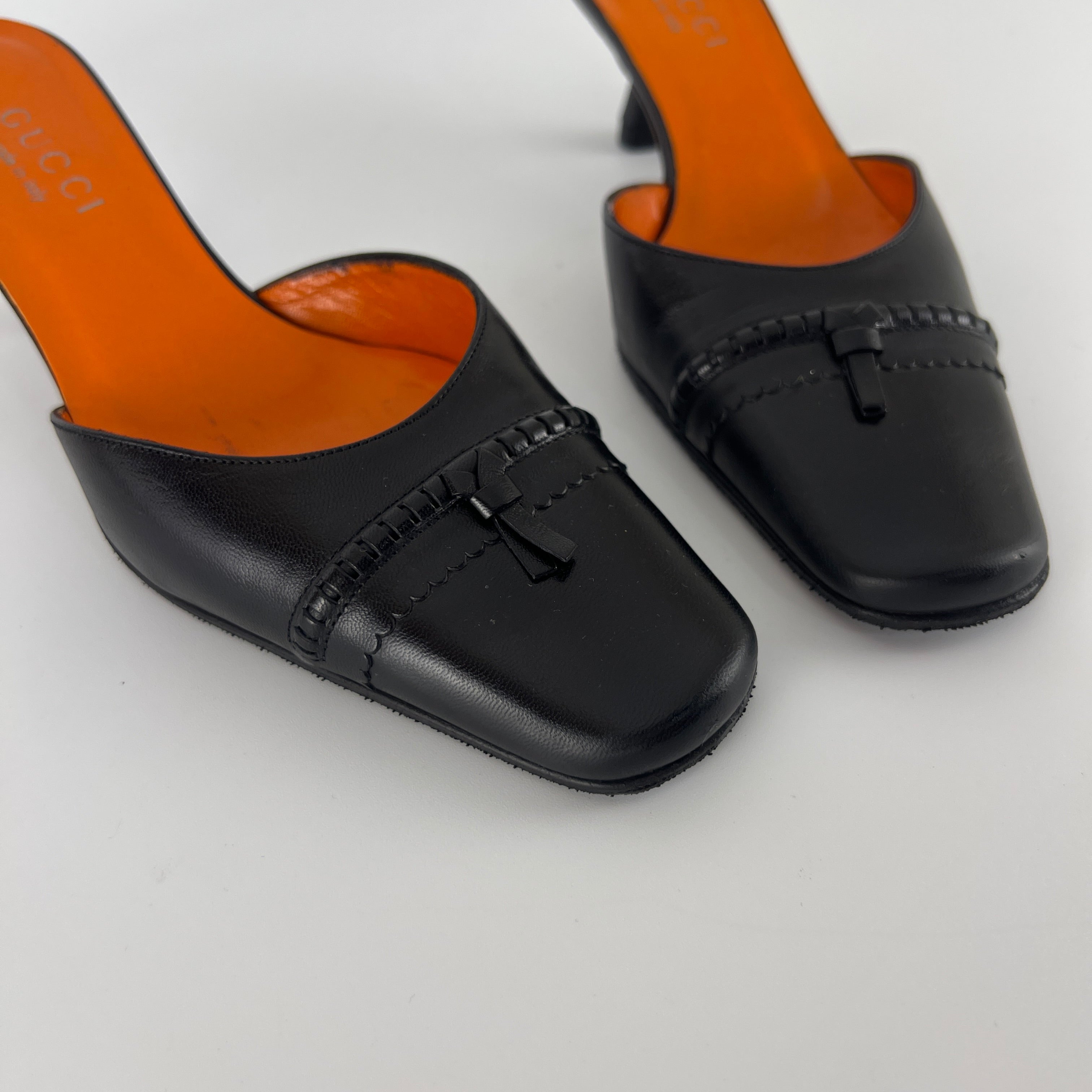 Gucci | Black Leather Closed Toe Brogue Tassel Orange Insole Mules (37C)