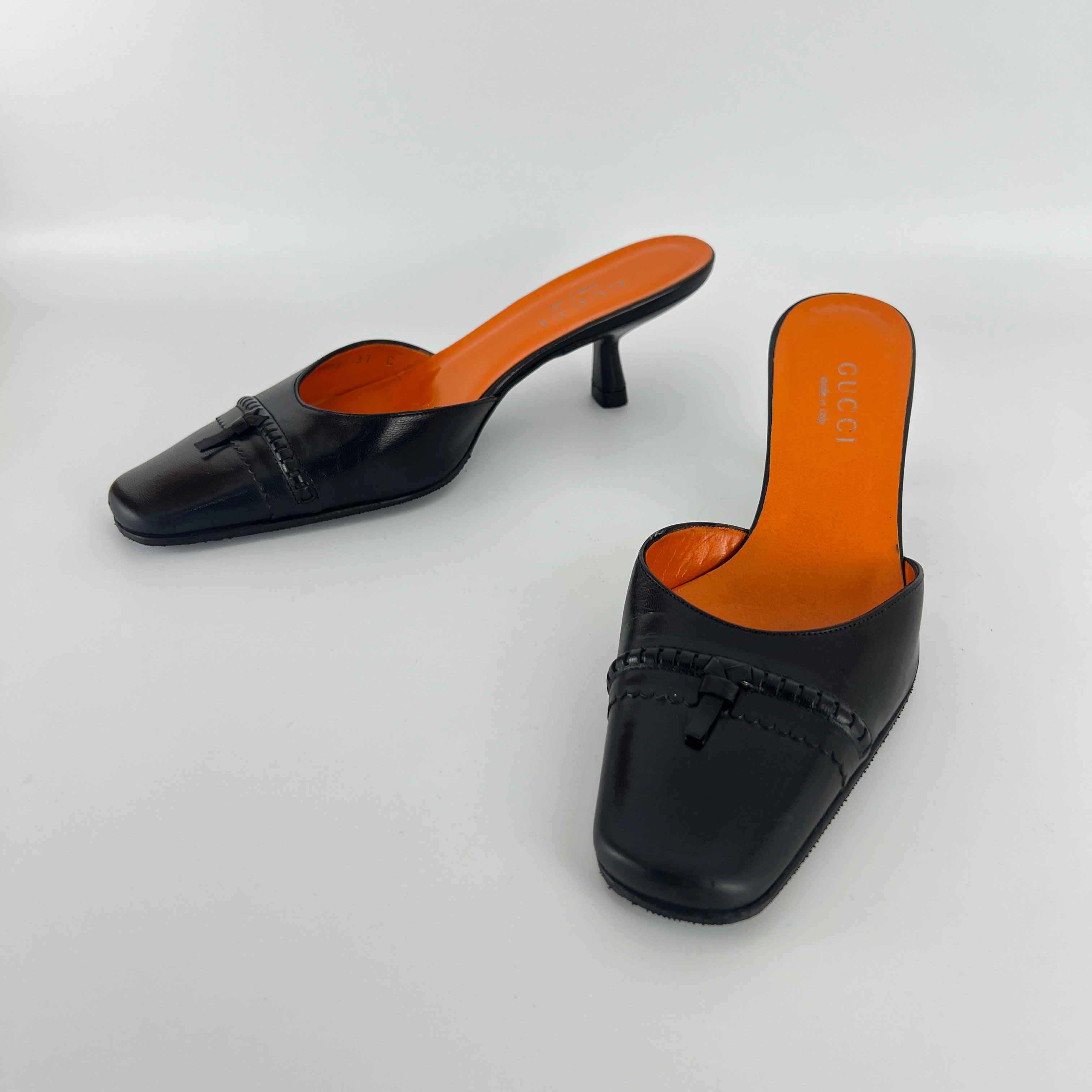 Gucci | Black Leather Closed Toe Brogue Tassel Orange Insole Mules (37C)