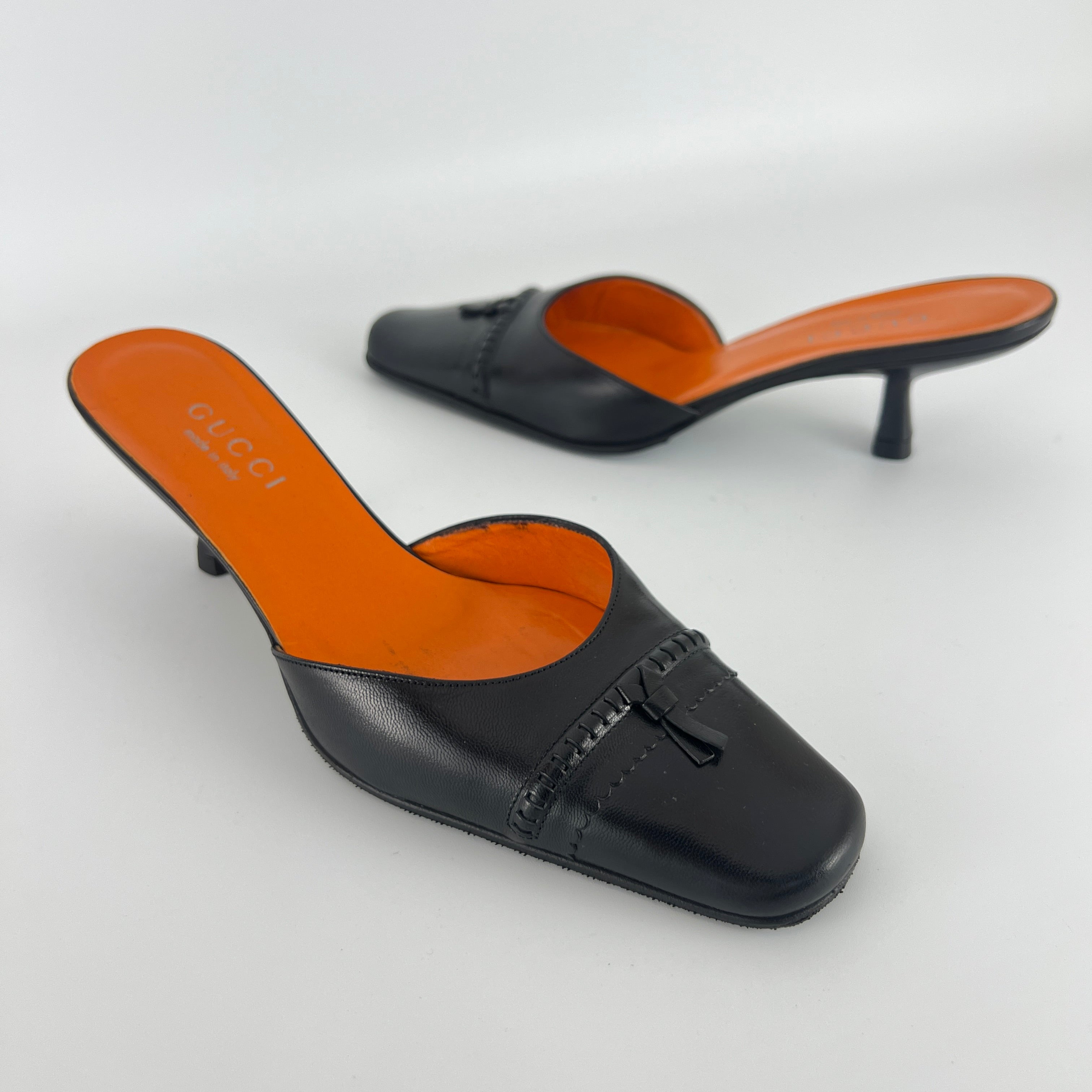 Gucci | Black Leather Closed Toe Brogue Tassel Orange Insole Mules (37C)