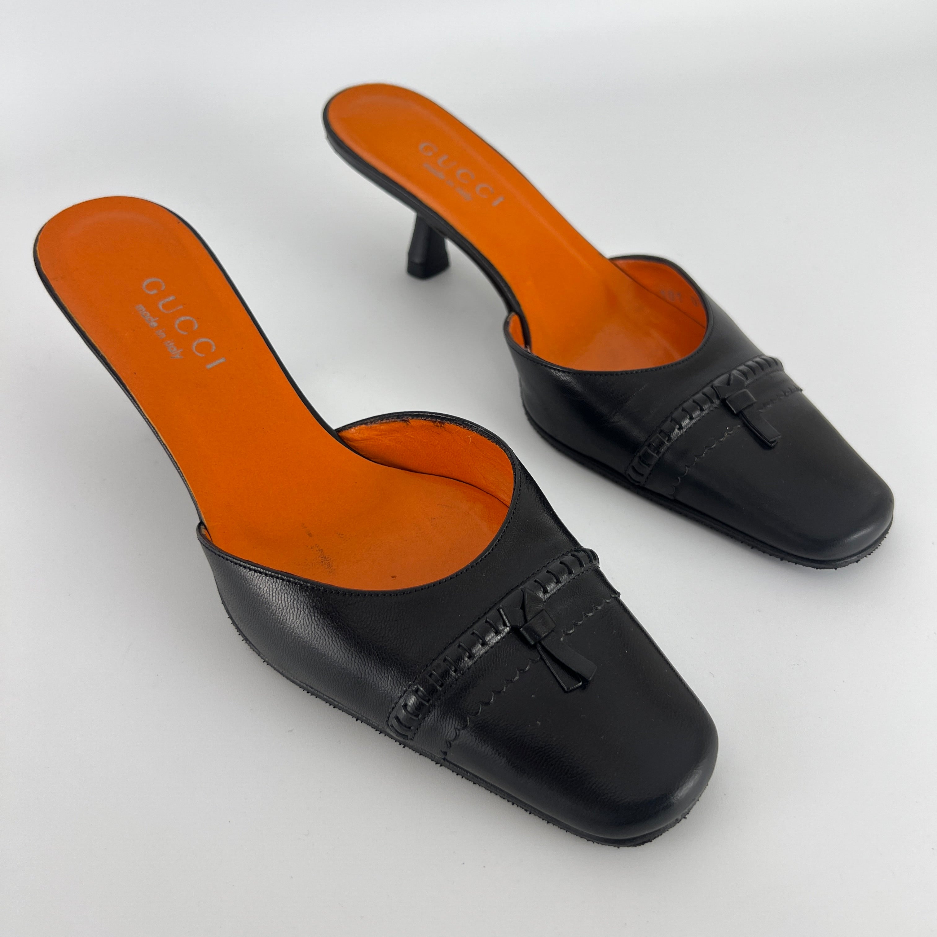 Gucci | Black Leather Closed Toe Brogue Tassel Orange Insole Mules (37C)