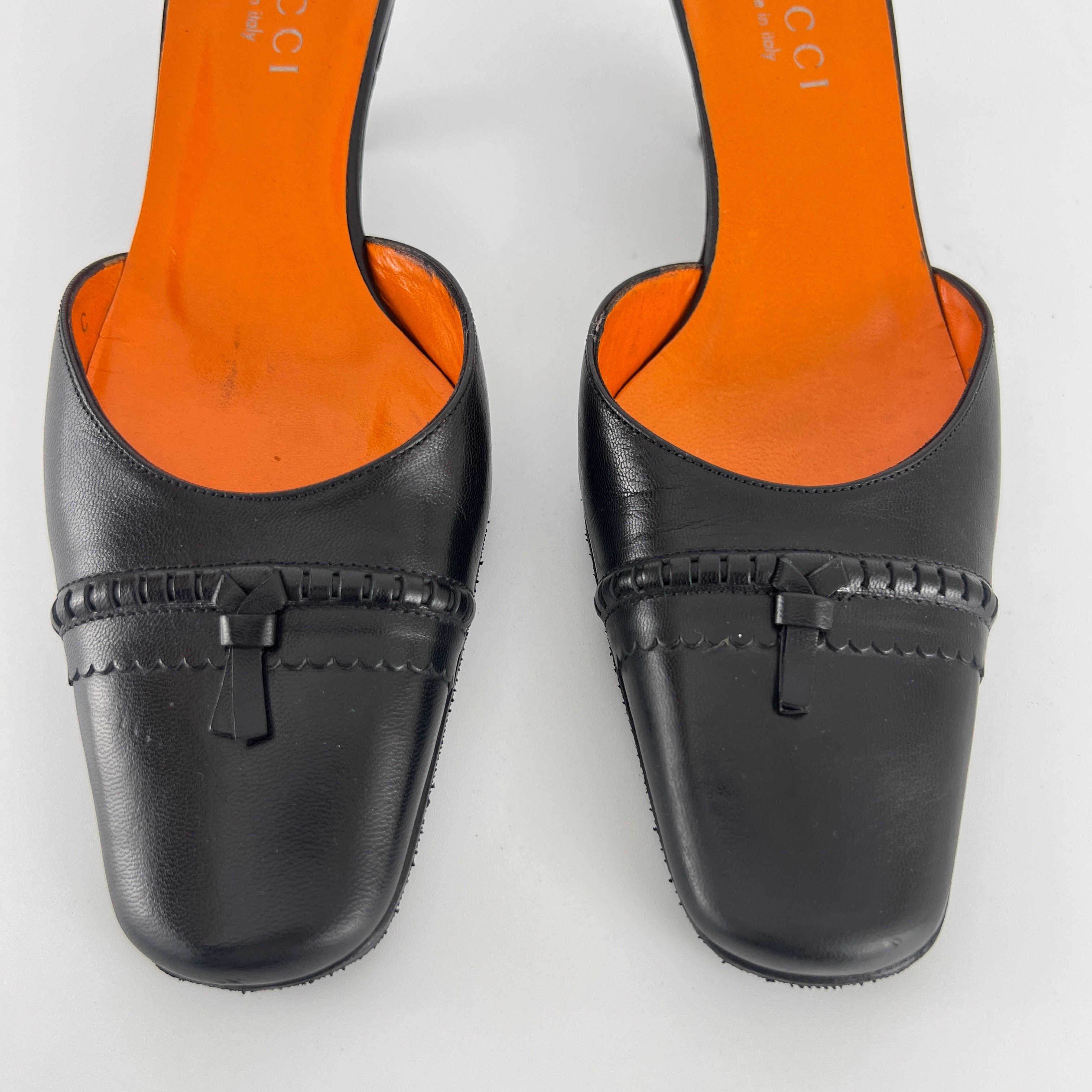 Gucci | Black Leather Closed Toe Brogue Tassel Orange Insole Mules (37C)