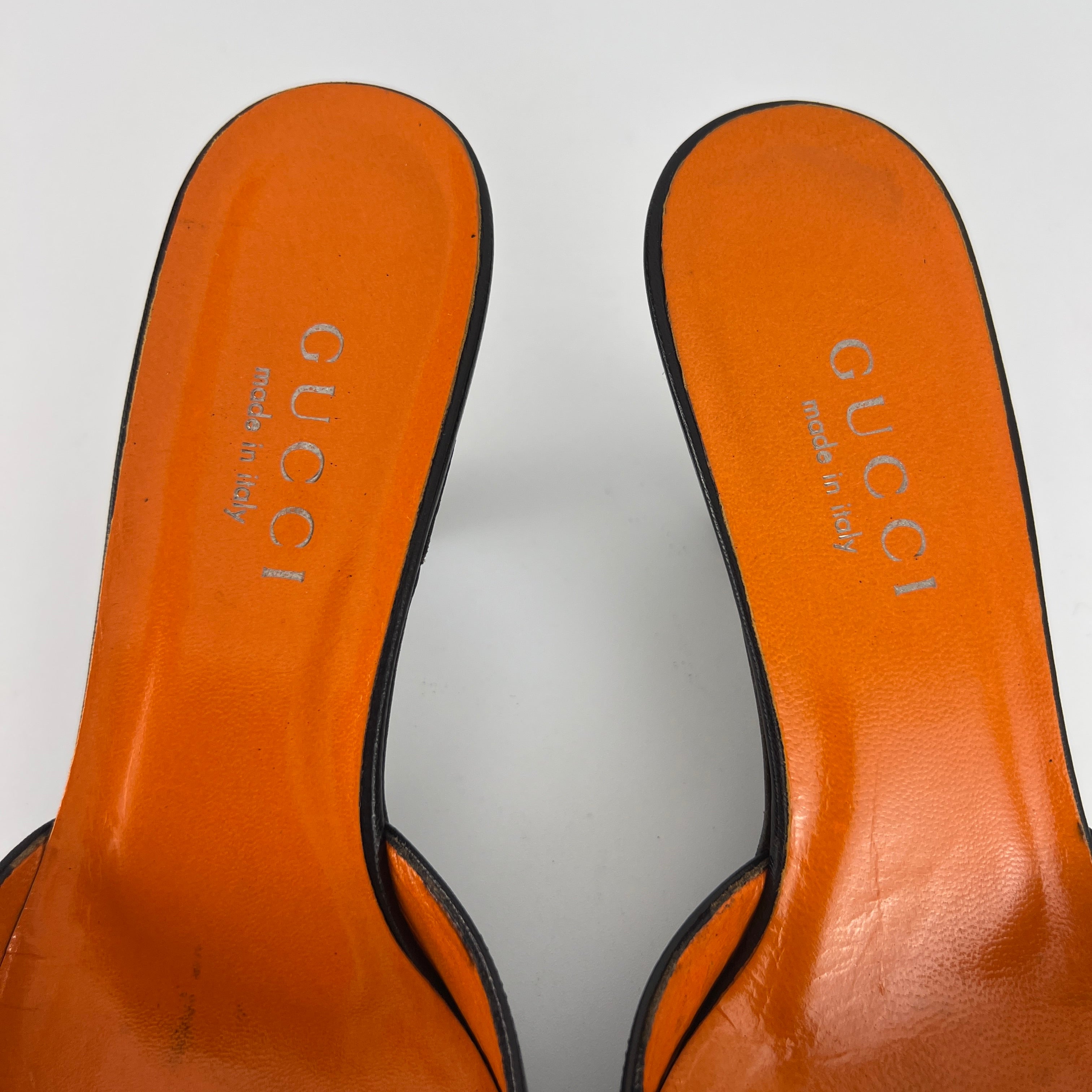 Gucci | Black Leather Closed Toe Brogue Tassel Orange Insole Mules (37C)