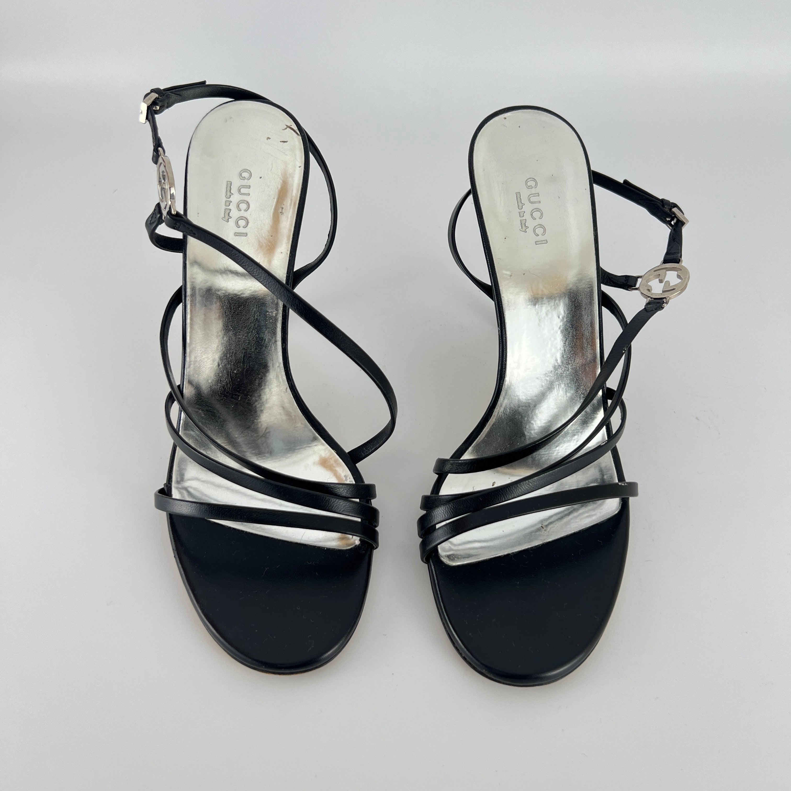 Gucci | GG Logo Silver Hardware Black Leather Metallic Insole Strappy Heels (37.5)