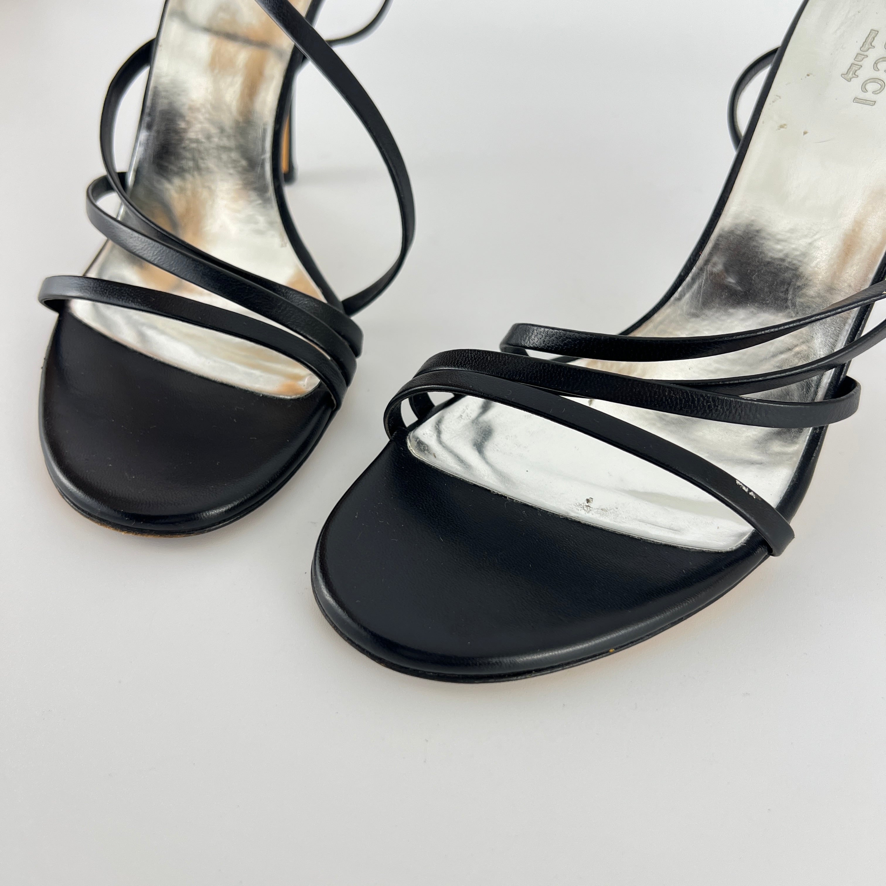 Gucci | GG Logo Silver Hardware Black Leather Metallic Insole Strappy Heels (37.5)