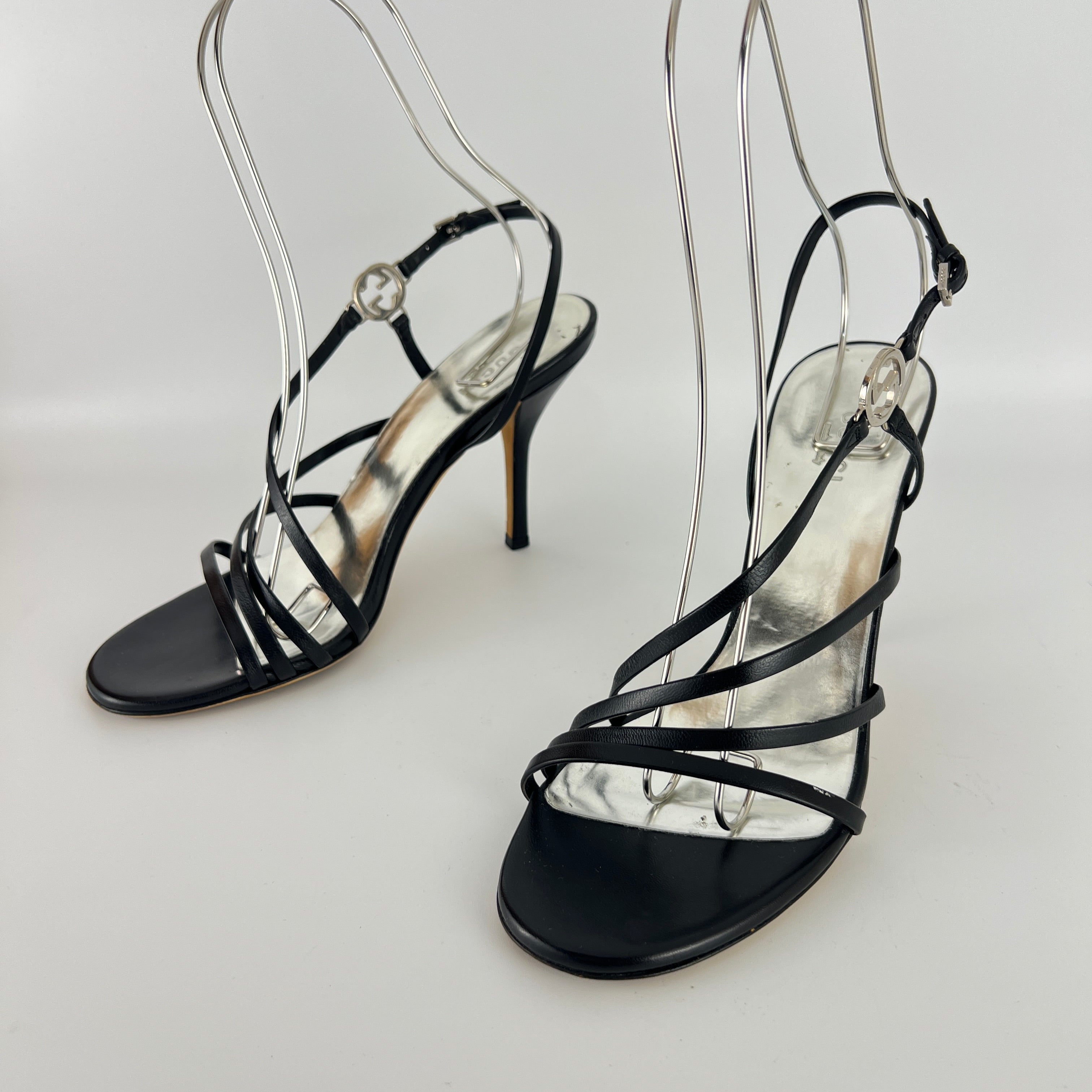 Gucci | GG Logo Silver Hardware Black Leather Metallic Insole Strappy Heels (37.5)