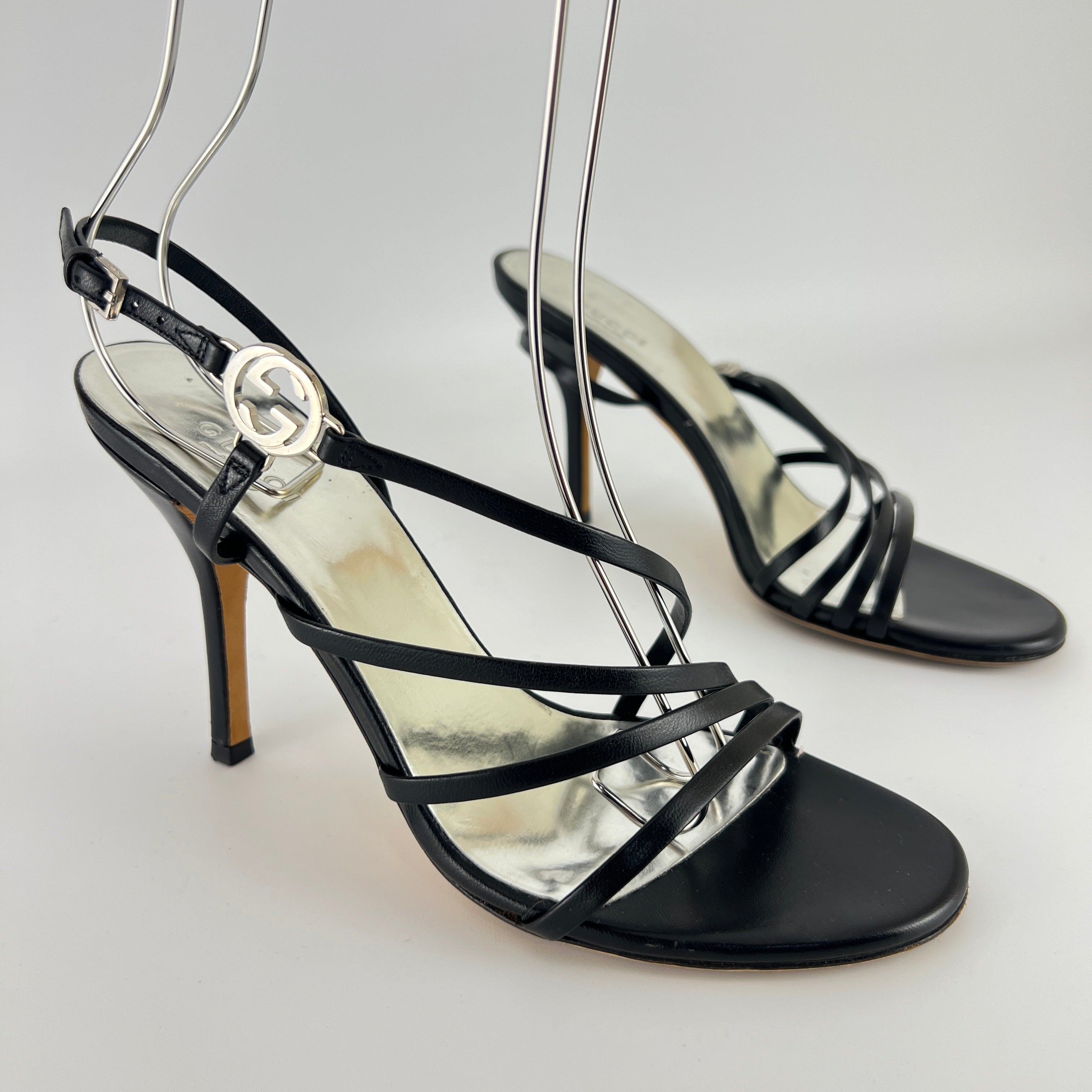Gucci | GG Logo Silver Hardware Black Leather Metallic Insole Strappy Heels (37.5)